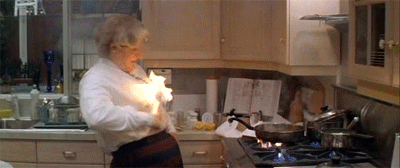 Vrouw staat in brand in de keuken en stopt het vuur met twee deksels