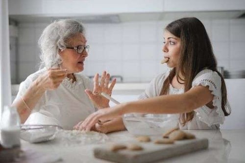 oma en kleindochter eten koekjes terwijl ze praten