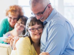 Un père serre dans ses bras sa fille atteinte du syndrome de Down