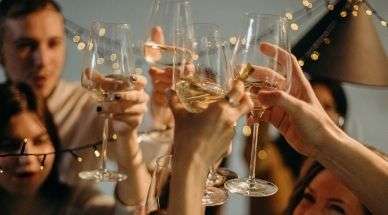 Mensen proosten met glazen witte wijn op een feest
